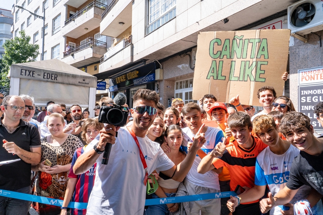Pablo Ordorica posa con aficionados que portan una pancarta de 'Cañita al like', la icónica frase del asturiano en sus vídeos. Movistar Team