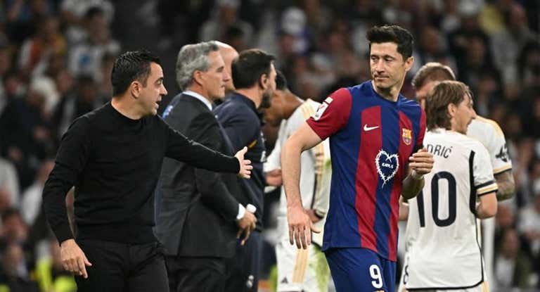Xavi conversa con Lewandowski en un Clásico de la temporada pasada.