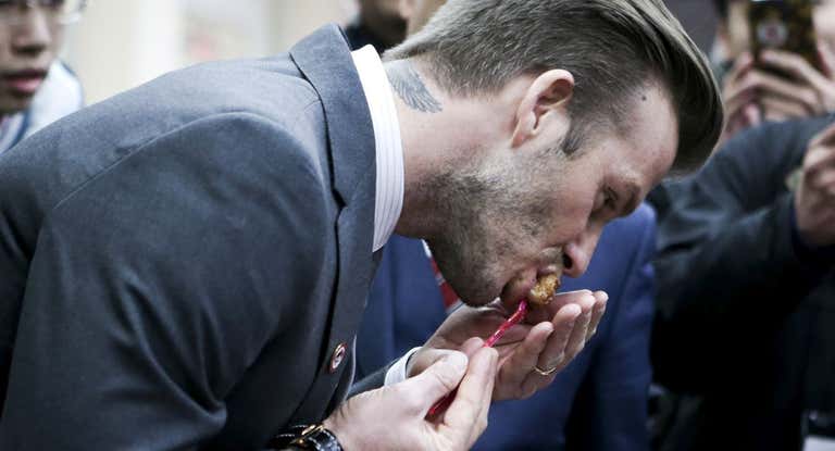 Beckham, comiendo durante un acto con el Real Madrid.