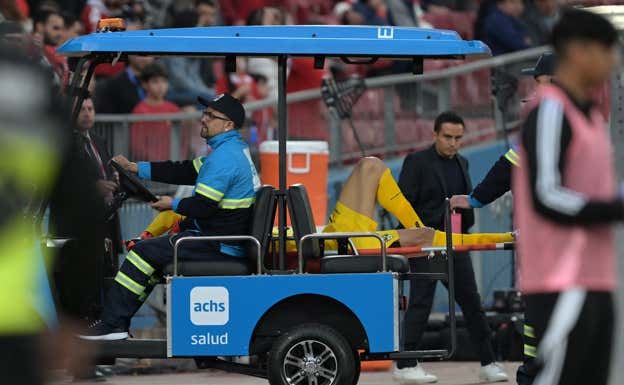 Lampe abandona el campo en camilla tras el gol chileno. AFP