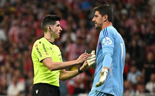 Thibaut Courtois, hablando con Busquets Ferrer.  AFP
