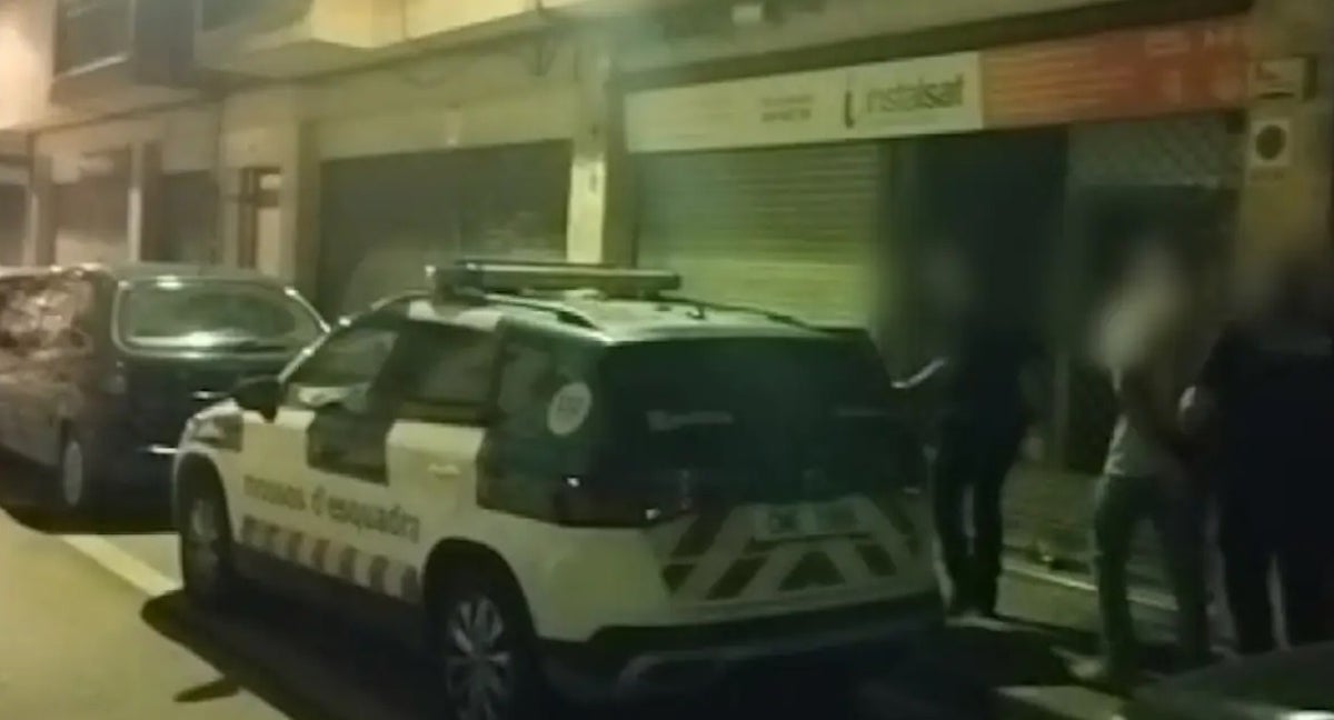 Agentes trasladan a uno de los detenidos tras la batalla campal de Cornellá.