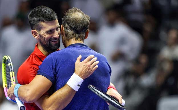Rafael Nadal y Novak Djokovic se abrazan en la red.  AFP