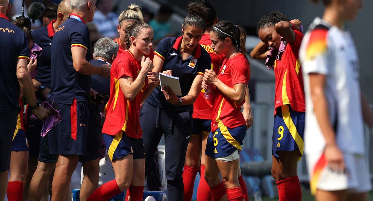 Montse Tomé da indicaciones a Aitana Bonmatí y Salma Paralluelo, jugadoras del Barça, durante un partido de la Selección en los JJ. OO.