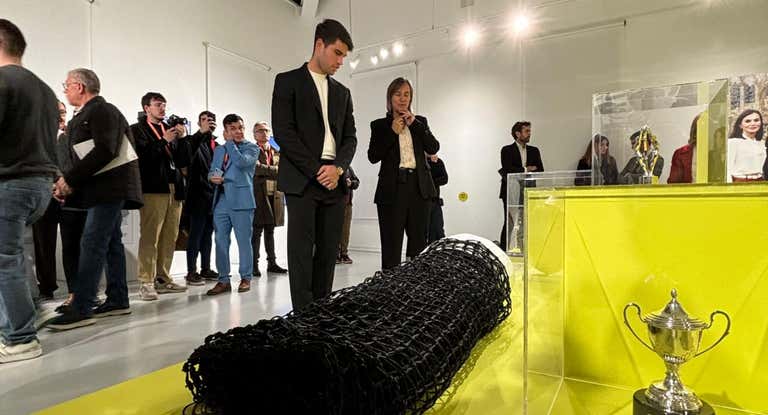 Carlos Alcaraz contempla la red durante la inauguración de la exposición «Los pies en la tierra».