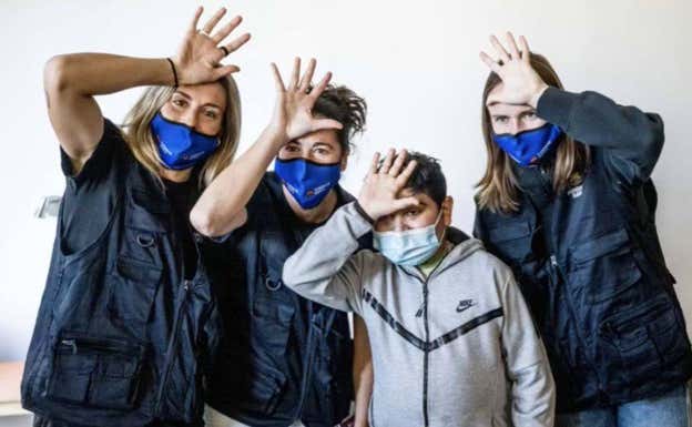 Alexia Putellas, Graham y Marta Torrejón posan con uno de los niños de Casa Xuklis.  FC BARCELONA FEMENINO