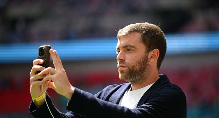 Fabrizio Romano se graba en un estadio de fútbol.