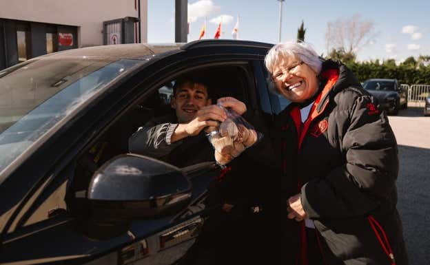 Lola entrega un paquete de magdalenas a Pedro Díaz, futbolista del Rayo Vallecano.  X