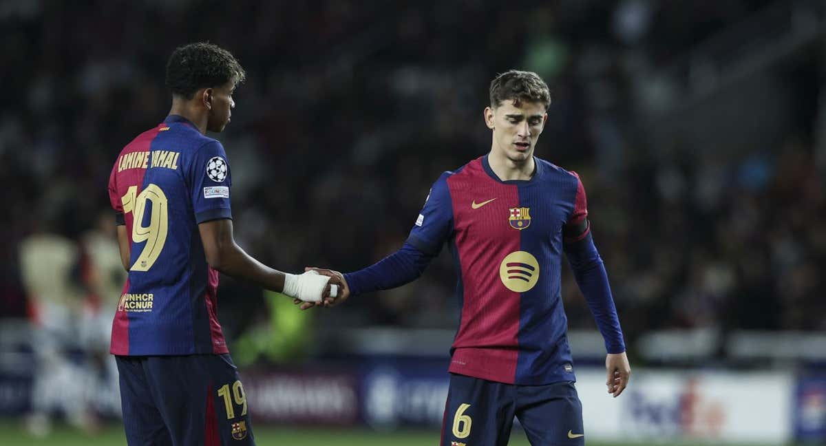 Lamine Yamal le da la mano a Gavi durante el Barça-Benfica. /GETTY