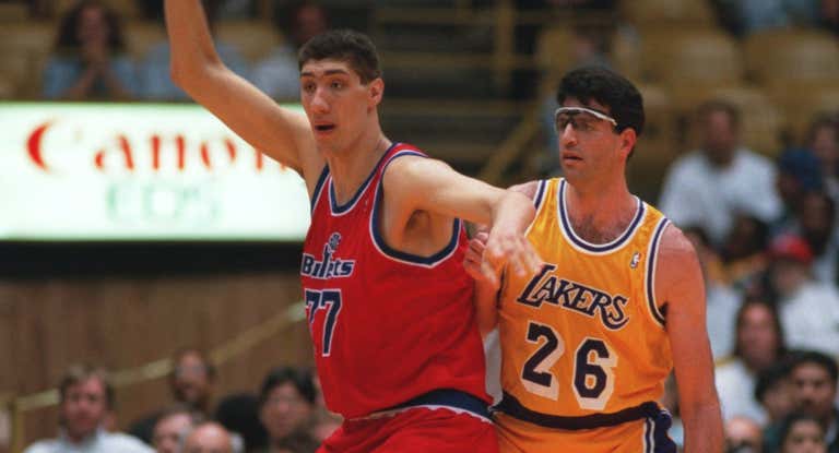 Gheorghe Muresan, de los entonces Washington Bullets, pelea por un balón en un partido contra los Lakers de marzo de 1994