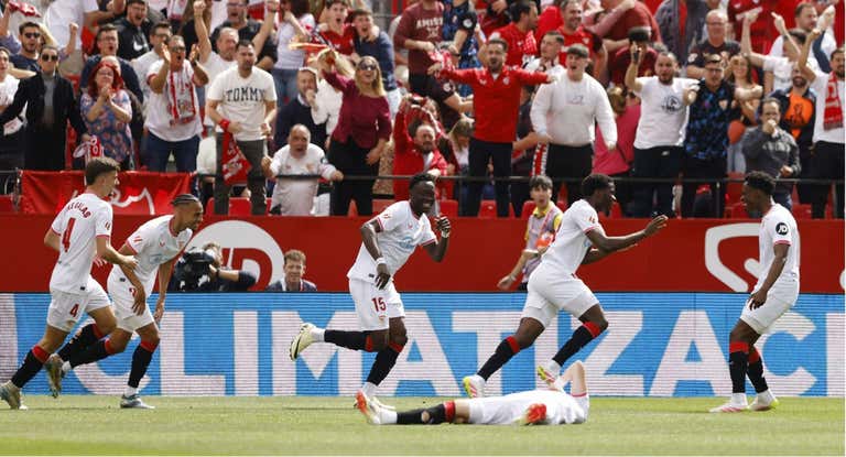 El Sevilla celebra el gol de Agoumé... con Vargas lesionado en el suelo.