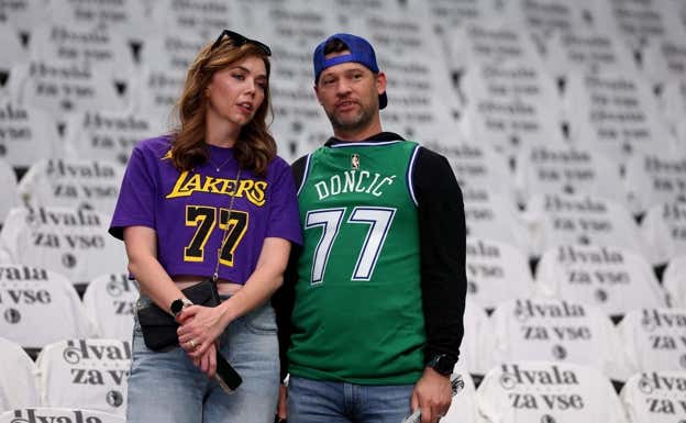 Dos aficionados, con las camisetas de Doncic de Lakers y Dallas, en el homenaje.  AFP